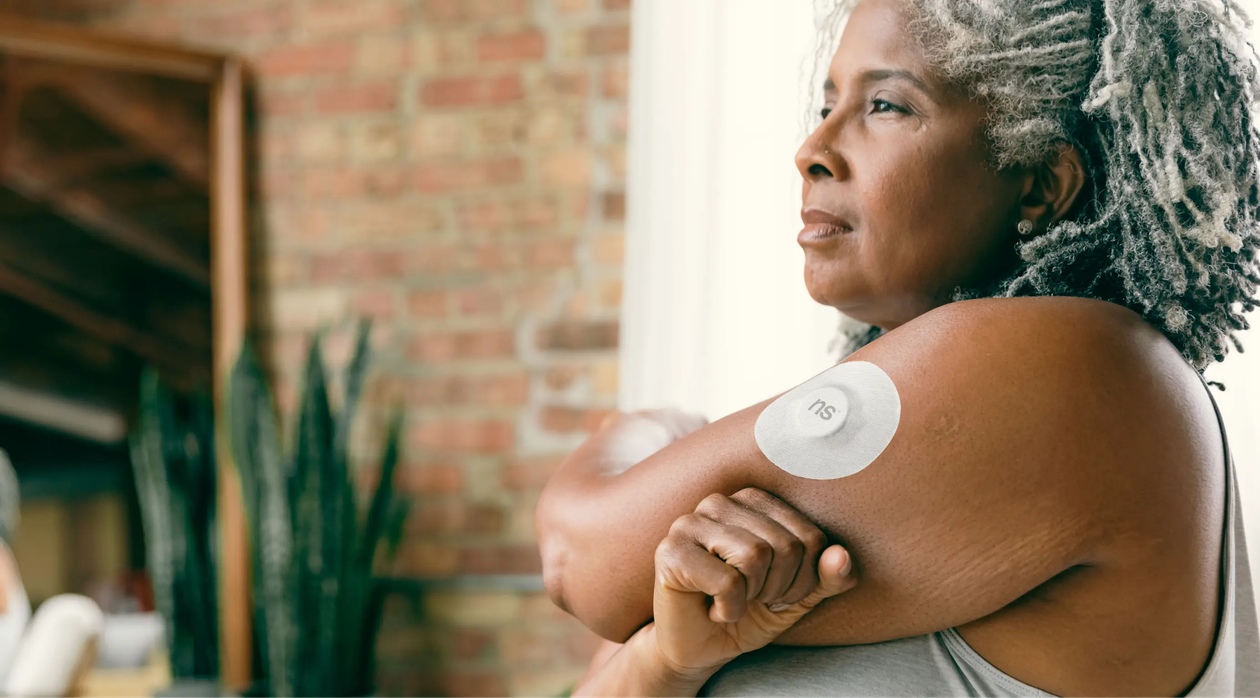 Mujer con dispositivo de monitoreo de glucosa